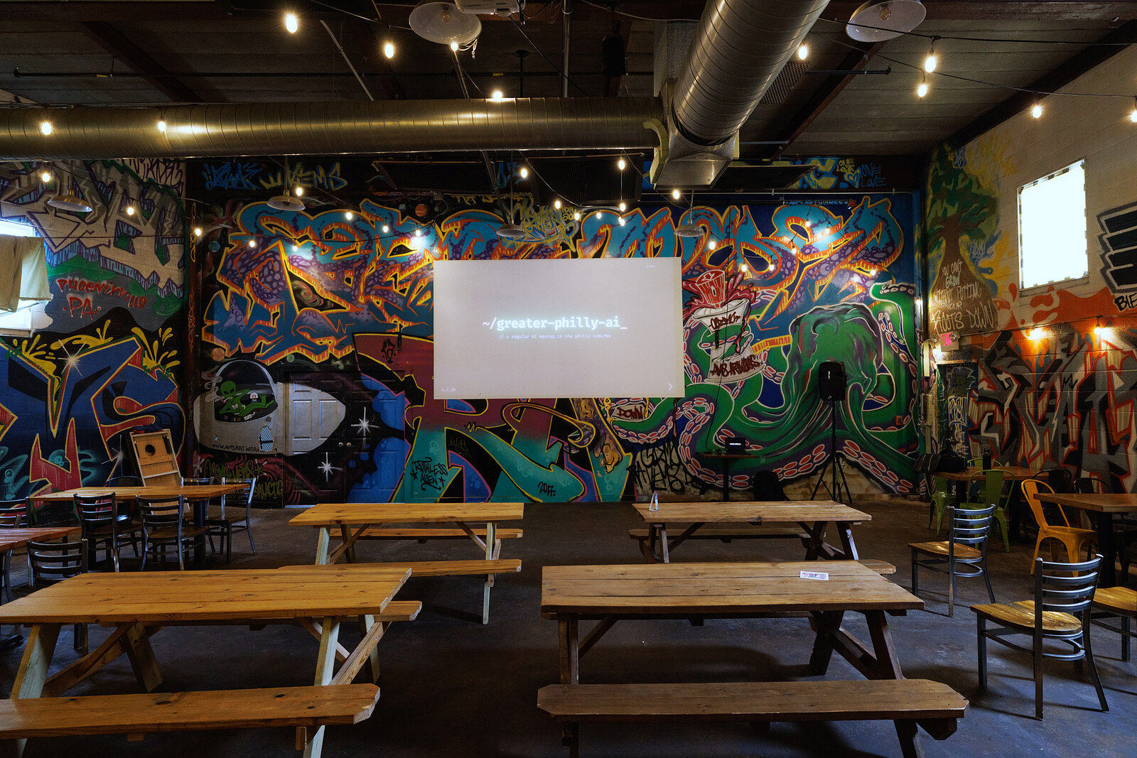 Root Down's main room with the opening slide projected on the mural