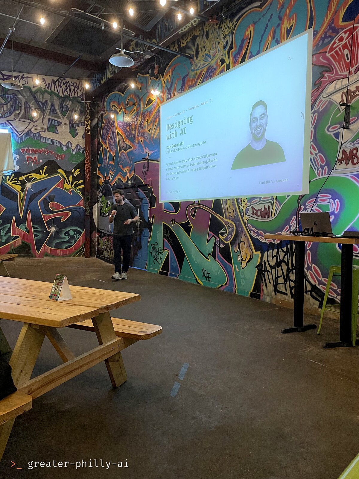 The Designing with AI title slide projected on the mural